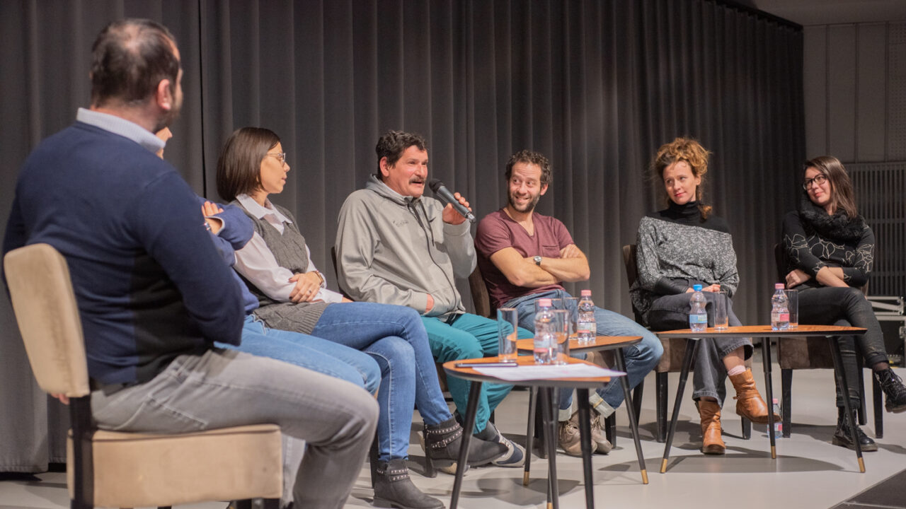 Panel of six people sitting on a stage, including Validity's client, Istvan Cservenka